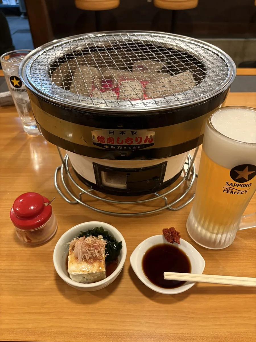 炭の入った七輪と生ビール、お通し、タレ