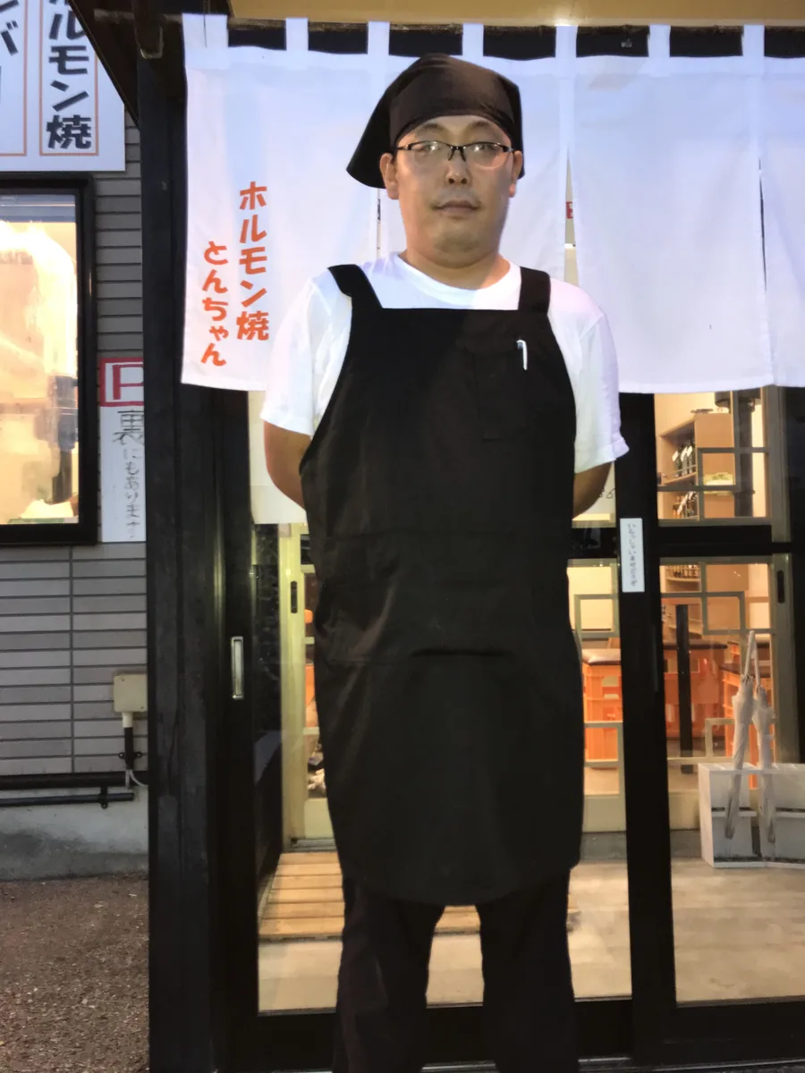 のれんの前に立つ、とんちゃんの店長